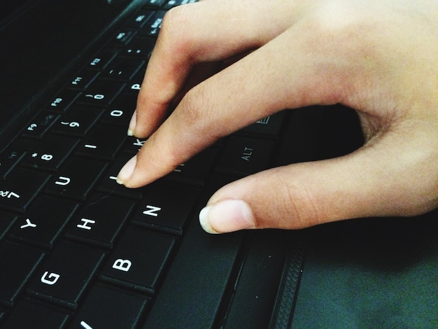 A person's hands typing on a keyboard, with a focus on the fingers and keys. The keys are subtly glowing with various colors, representing the flow of data. The background is blurred, highlighting the action of typing.