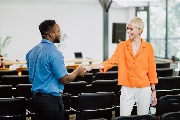 A government official shaking hands with a public service employee, such as a teacher or nurse, symbolizing the potential benefits of the PSLF program.