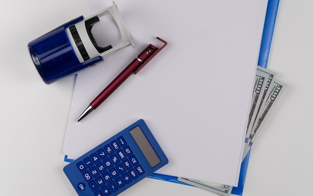 A calculator resting on a stack of tax documents with a pen nearby, symbolizing the detailed calculation process of the QBI deduction.