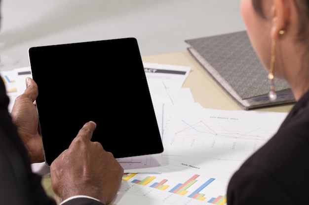 A person analyzing financial data on a tablet, with charts and graphs displayed on the screen. The setting is a modern office, and the person is focused on optimizing their investment portfolio.