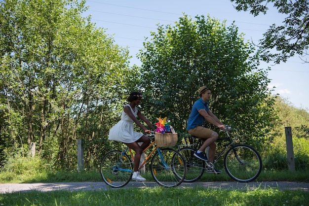 A diverse group of people riding bikes in a city park, with trees and green spaces surrounding them. The image promotes cycling as a healthy and environmentally friendly mode of transportation.