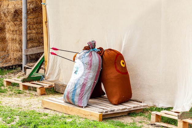 A person lifting a homemade sandbag in their backyard. The sandbag is made from a durable duffel bag and filled with sand, showcasing a simple and effective DIY solution.