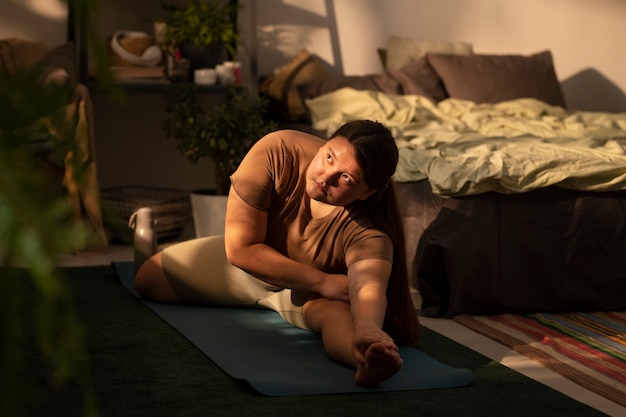 A person practicing stretching exercises in a dimly lit room before bedtime, emphasizing relaxation and preparation for sleep. Show the focus on unwinding and calming the body.