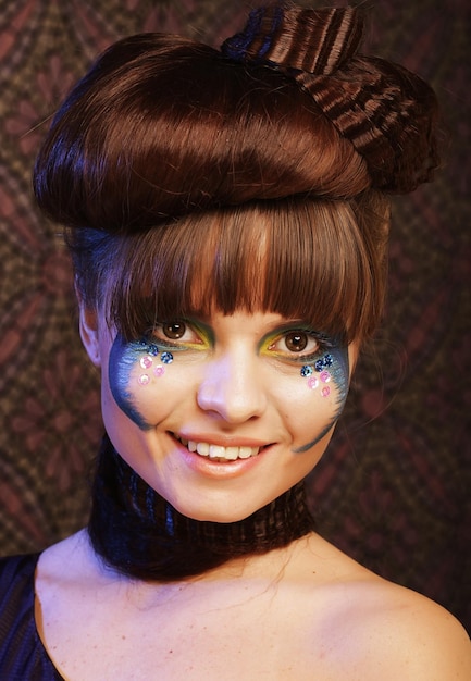 A cosplayer's face, showing detailed and vibrant makeup that transforms their appearance into the character they are portraying. The focus is on the intricate details of the makeup, highlighting the use of color, shading, and special effects to achieve a realistic and captivating look.